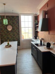 a kitchen with a white counter top and a window at Field Maple -free parking -Grade II listed- first floor two bedrooms apartment in Huntingdon