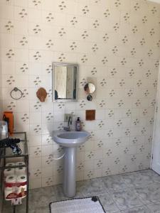 y baño con lavabo y espejo. en Prainha Pousada - Bar e Restaurante, en Itanhaém