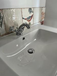 lavabo blanco con grifo en el baño en Field Maple -free parking -Grade II listed- first floor two bedrooms apartment, en Huntingdon