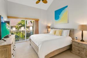 a bedroom with a large bed and a window at Koolkondo Luxury Designer Condo in Koloa +20 photos