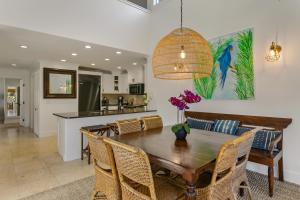 a dining room with a wooden table and chairs at Koolkondo Luxury Designer Condo in Koloa
