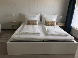 1 cama blanca grande con 2 almohadas en Vikerhavn, Hvaler, 