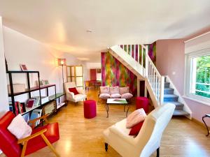 a living room with a staircase and a couch and chairs at BERNARDINE - Hyper Centre Reims Parking Inclus in Reims