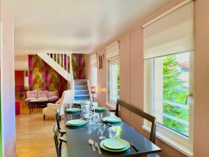 uma sala de jantar com uma mesa com cadeiras e uma janela em BERNARDINE - Hyper Centre Reims Famille em Reims