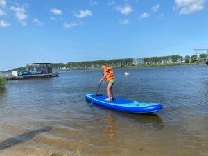 une personne sur une planche de paddle dans l'eau dans l'établissement EcoRelax, à Błotnik