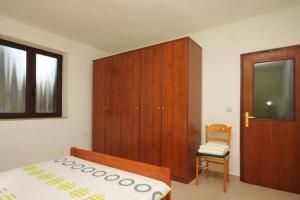 a bedroom with a bed and a cabinet and a chair at MURIN DELFIN in Umag