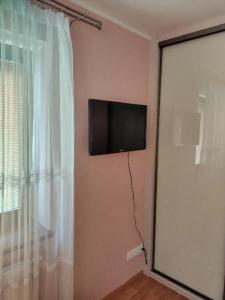a flat screen tv on a wall next to a window at Pozlovice225 in Pozlovice