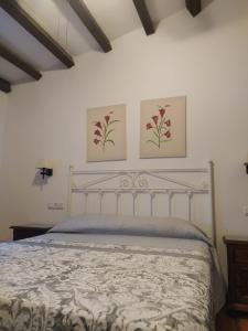 Un dormitorio con una cama con dos cuadros en la pared. en Casa Rural Alamillo, en Luque 23 fotos más
