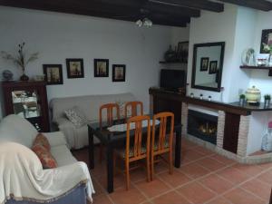 sala de estar con mesa, sillas y chimenea en Casa Rural Alamillo, en Luque