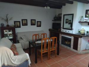Una sala de estar con mesa y sillas y una chimenea. en Casa Rural Alamillo, en Luque