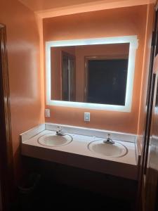 baño con 2 lavabos y espejo grande en Washington & Lee Motel, en East End