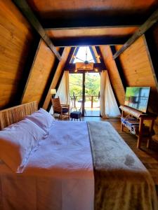 a bedroom with a large bed in a attic at Casa Baldoni - Fazenda de Café in Santa Rita do Sapucaí