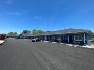 un edificio azul con un coche aparcado en un estacionamiento en Washington & Lee Motel, en East End