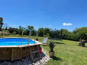 a pool in a yard with a chair and a playground at Les volets bleus 