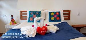 a bed with towels and a heart on it at Vila Bello Pontal in Coruripe