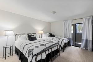 zwei Betten in einem Schlafzimmer mit weißen Wänden in der Unterkunft Luxurious 2 Bedroom Base Camp Condo - Steps from Kirkwood Village condo in Kirkwood