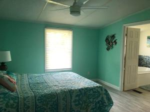 a blue bedroom with a bed and a window at Quiet Gateway close to the Marina, Beach and Base in Sneads Ferry