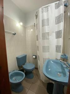 een badkamer met een blauw toilet en een wastafel bij MAKTUB HOSTERIA in El Bolsón