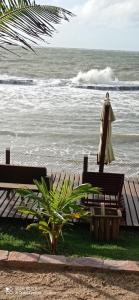 コルリッペにあるVila Bello Pontalの海の横のベンチ2つと傘