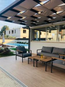 a patio with a couch and a table and a pool at Apartments Angelo in Bibinje