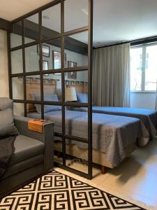 バラ・マンサにあるStudio aconchegante em Barra Mansaのベッドルーム1室(二段ベッド2台、ソファ付)