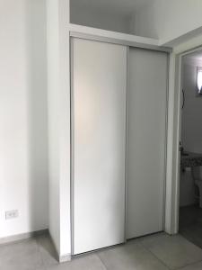 2 porte scorrevoli in una stanza con pareti bianche di Alquiler temporal frente Hospital Italiano a San Justo