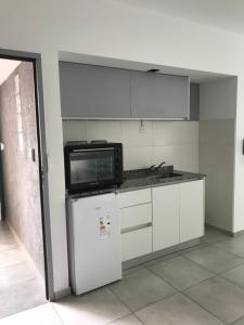 a kitchen with a microwave and a refrigerator at Alquiler temporal frente Hospital Italiano in San Justo