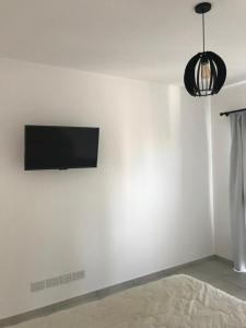 a room with a flat screen tv on a white wall at Alquiler temporal frente Hospital Italiano in San Justo