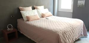 a bedroom with a white bed with pink and white pillows at Il Vascello in Rapallo