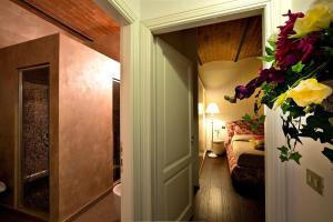 einen Flur mit einem Zimmer mit einem Bett und Blumen in der Unterkunft Agriturismo Belagaggio in Montefollonico