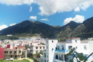 a view of a city with mountains in the background at Ali Baba complete Apartment Hostel 8Person in Chefchaouen