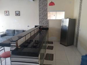 a kitchen with a couch and a refrigerator at Casa na roça Recanto Vale Do Sol in São Pedro da Aldeia