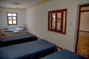 a bedroom with two beds and a mirror and a window at Ali Baba complete Apartment Hostel 8Person in Chefchaouen