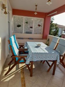 a table and chairs on a balcony with a table and a table and chairs at Acharavi, villa next to the beach in Acharavi