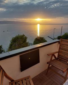 balcón con TV, silla y puesta de sol en Apartment Mara, en Senj