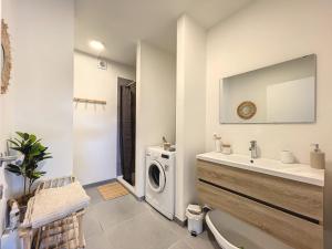 een badkamer met een wasmachine en een wastafel bij Sweet Moments in Hargimont