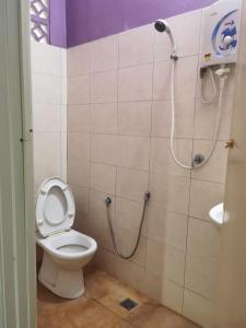 La salle de bains est pourvue d'une douche et de toilettes. dans l'établissement Padua inn, à Batu Ferringhi