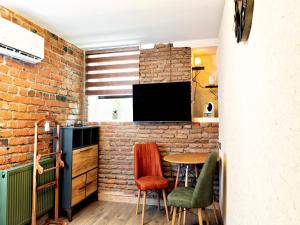 una pared de ladrillo en una cocina con mesa y sillas en 6 Unique Apartments en Tiflis