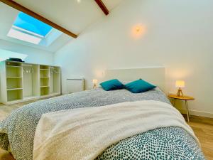a bedroom with a large bed with blue pillows at *ARENA* - duplex lumineux in Reims