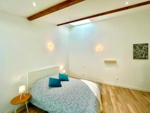 um quarto com uma cama com almofadas azuis em *ARENA* - duplex lumineux em Reims