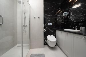 加茨比亞格拉的住宿－Morskie Apartamenty Albatros i Góral，黑白浴室设有卫生间和淋浴。