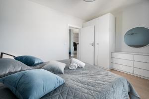 加茨比亞格拉的住宿－Morskie Apartamenty Albatros i Góral，一间卧室配有一张带蓝色枕头和镜子的床