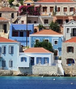 a group of houses on the shore of the water at Halki Sea Breeze - a waterfront villa in Halki