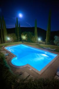 una grande piscina di notte con la luna sopra la testa di Agriturismo Belagaggio a Montefollonico