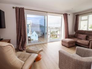 a living room with a large window and a couch at The Old Tywyn Post Office in Conwy