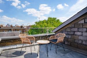 three chairs and a table on a balcony at Be London - The Covent Garden Residences in London