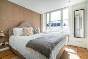 a bedroom with a large bed and a window at Be London - The Covent Garden Residences in London