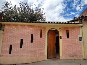 un edificio de ladrillo con una puerta y un árbol en la parte superior en Casa Tribu, en Huaraz