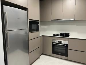a kitchen with a stainless steel refrigerator and a microwave at Eaton Suites KLCC in Kuala Lumpur