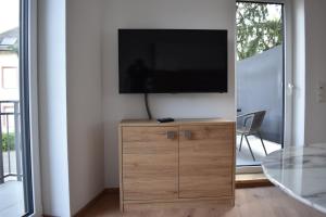 a flat screen tv sitting on top of a wooden cabinet at Weingut Lindenhof Kröhler 